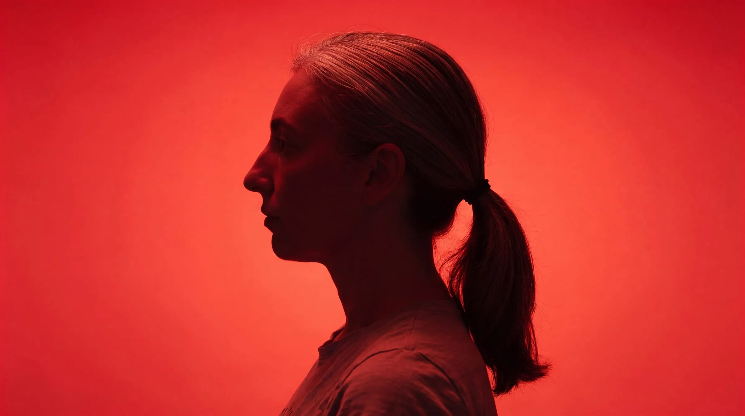Kate Colmer in profile, lit in orange